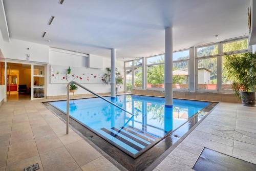 ein großer Pool in einem großen Zimmer mit Fenstern in der Unterkunft Aparthotel Philipp in Serfaus
