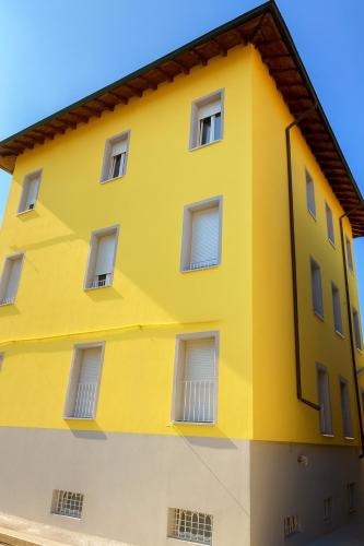 a yellow building with white windows at Palazzo Gregorio in Parma