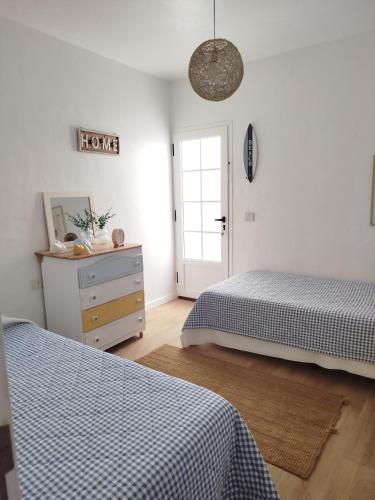 a bedroom with two beds and a dresser and a door at Casa Sebadal in La Santa