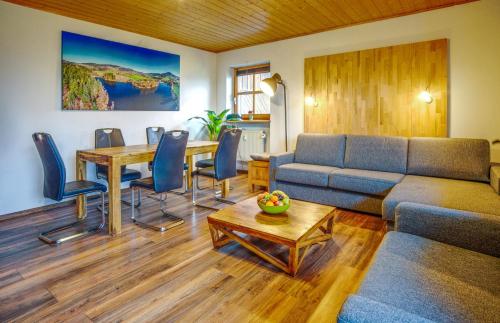 una sala de estar con un sofá y una mesa en Ferienwohnung Freudensee im Bayerischen Wald - Pool, Sauna, en Hauzenberg