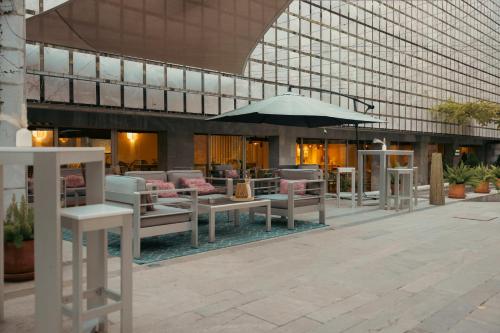 een groot gebouw met tafels en een parasol bij Hospes Palacio de los Patos, a Member of Design Hotels in Granada