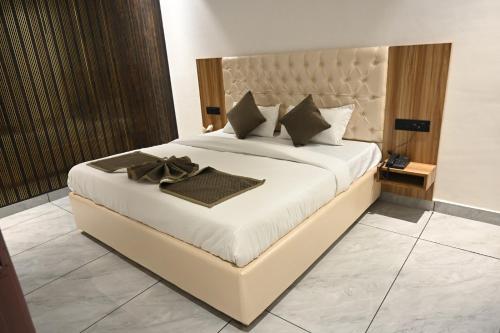 a bedroom with a large bed with white sheets and pillows at Troy Resorts and wellness in Zirakpur