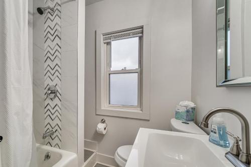 a bathroom with a sink toilet and a window at Game Room and Backyard Modern Altoona Home! in Altoona