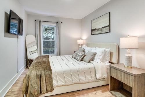 a white bedroom with a bed and a window at Game Room and Backyard Modern Altoona Home! in Altoona