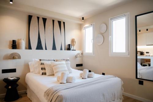Un dormitorio con una cama blanca con toallas. en Jávea Boutique Stays - Holiday Apartments, en Jávea