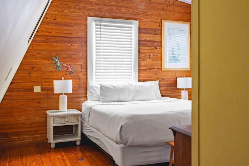 a bedroom with a white bed and a window at Curry House- 3rd Floor, King Bed, & Balcony Room 8 in Key West