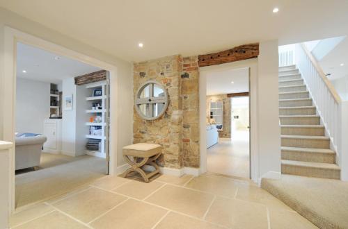 a hallway with stairs and a stone wall at The Tide House in St Ives
