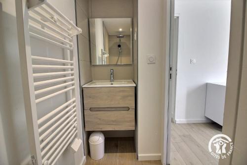 un bagno con lavandino e specchio di Ty gouldri a Perros-Guirec