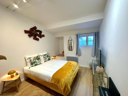 a bedroom with a large bed and a window at Charmant deux pièces en plein centre-ville de NARBONNE in Narbonne