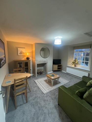 a living room with a green couch and a table at 1 Gilmore Close in Alston