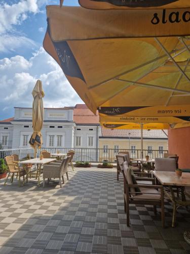 a patio with tables and chairs and umbrellas at Hotel Bela Krajina in Metlika
