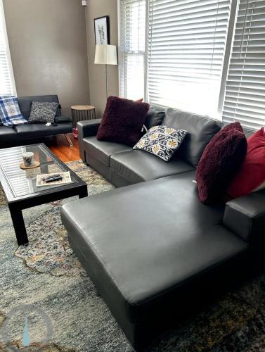 a living room with a leather couch and a coffee table at Spacious 4BR Close to Airport for Work and Families in Columbus