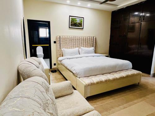 a bedroom with two beds and a couch at OSMA Residency in Islamabad