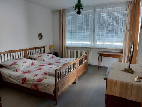 een slaapkamer met een bed en 2 ramen en een tafel bij Antoinette Kurappartement in Bad Krozingen