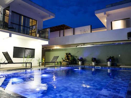 a large swimming pool in front of a house at Home Aguas da barra Ilhabela in Ilhabela