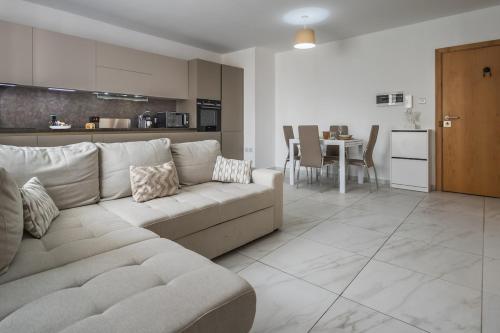 Wild Thyme - By Solea Holiday Homes في San Ġwann: غرفة معيشة مع أريكة ومطبخ