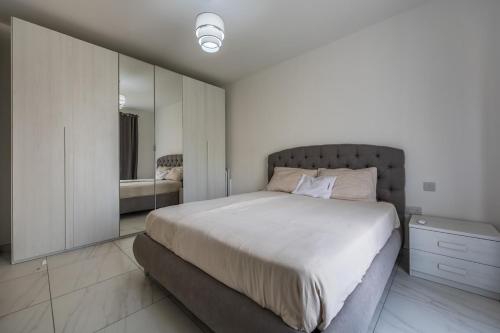 a bedroom with a large bed and a mirror at Wild Thyme - By Solea Holiday Homes in San Ġwann