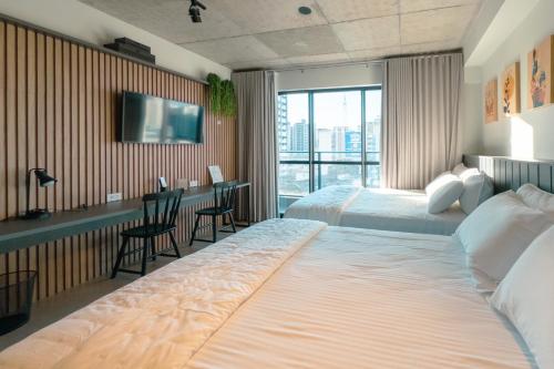 马林加Excelente Espaço Centro CA904的一间酒店房间，里面有两张床和一张桌子。