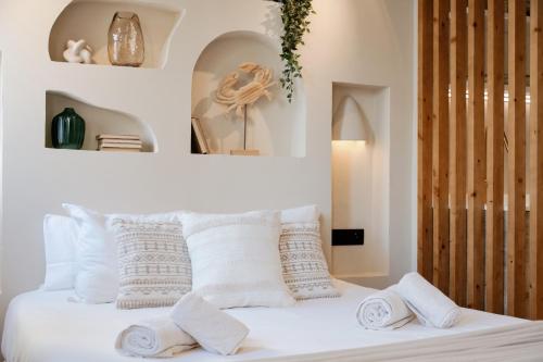 Una cama blanca con almohadas blancas encima. en Jávea Boutique Stays - Holiday Apartments, en Jávea