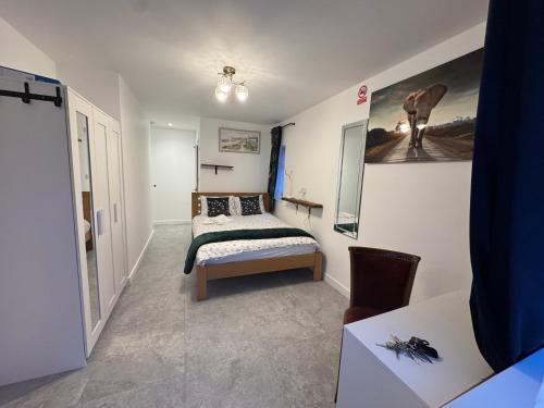 a bedroom with a bed and a table in it at Bota Property in Kidlington