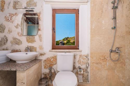 a bathroom with a toilet and a sink and a window at Villa Elvin in İslâmlar