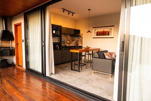 Loft Cerrado de Minas في جوبوتيكاتوباس: مطبخ وغرفة معيشة مع طاولة وكراسي