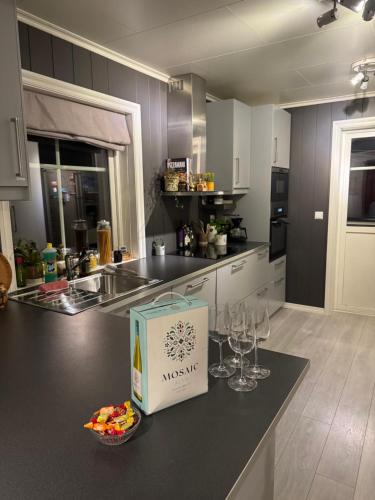 a kitchen with wine glasses and a bag on a counter at Stylish toppleilighet med flott utsikt - sentralt in Vossevangen