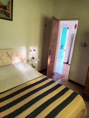 a bedroom with a bed with a striped blanket at complejo cumelen in Gualeguaychú