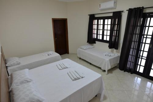 Zimmer mit 2 Betten und 2 Fenstern in der Unterkunft Casa Familiar Morada in Aparecida