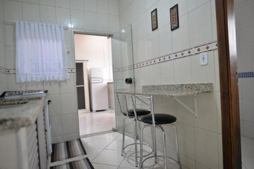 eine Küche mit zwei Barhockern in einem Zimmer in der Unterkunft Casa Familiar Morada in Aparecida