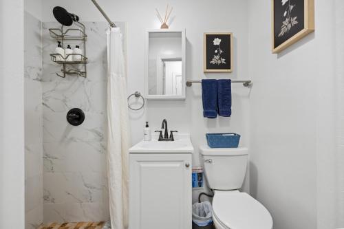 a white bathroom with a toilet and a sink at Highly Recommended Studio Near Times Square in New York