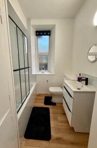 a bathroom with a toilet and a sink and a window at The Nairn Neuk - Couples Cosy Getaway in Nairn