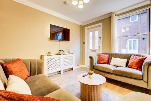 a living room with two couches and a tv at Cottage in the centre in Colchester