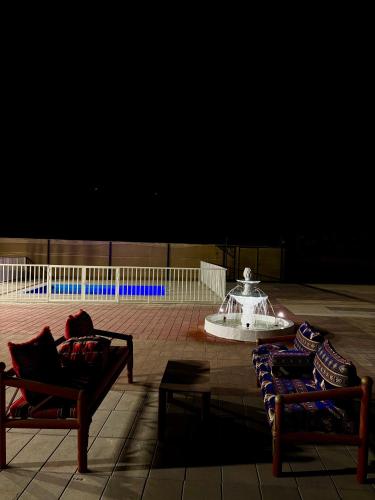 two chairs and a fountain in the middle of a patio at Alawadhi Farm 1 in Ras al Khaimah
