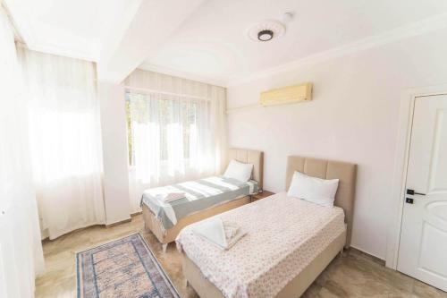 una camera da letto con due letti e una finestra di Villa Serafina a Mergenli