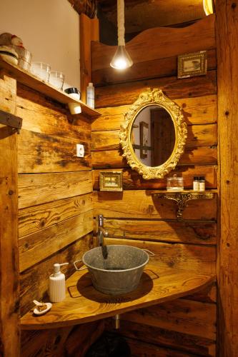 a wooden bathroom with a sink and a mirror at La Ferme d'Angele in Séez