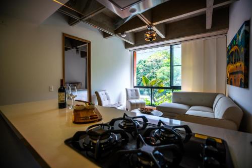 a kitchen and living room with a stove top at Home away from home - By Adri in Envigado