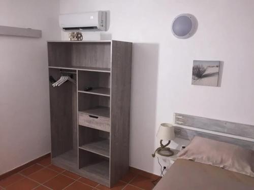 estante de libros en una habitación con cama en Bungalow confortable avec piscine à Le Lamentin, en La Belème