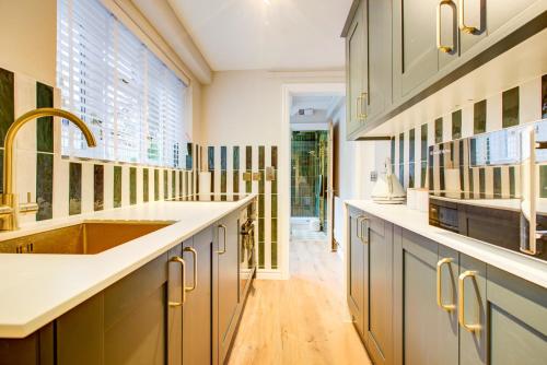 een keuken met een spoelbak en een aanrechtblad bij Cottage in the centre in Colchester