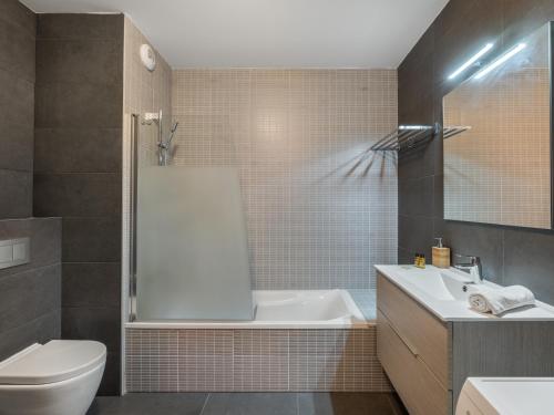 a bathroom with a tub and a toilet and a sink at L'O Rouge - Apt A02 - BO Immobilier- remises sur les forfaits de skis Châtel ou Portes du soleil in Châtel