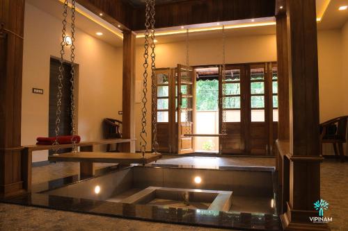 a room with a large tub in the middle of a room at Vipinam, The riverside retreat in Kotamangalam