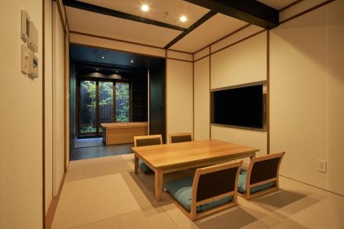 a dining room with a wooden table and chairs at Kikuyu No Yado in Kyoto