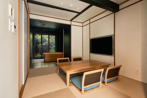a dining room with a wooden table and chairs at Kikuyu No Yado in Kyoto