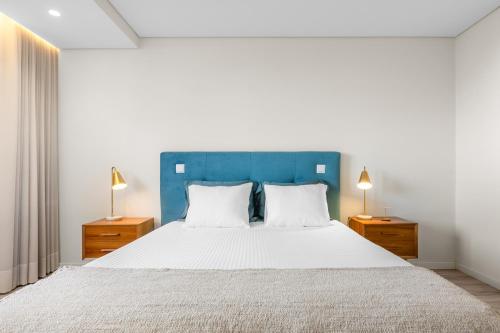 a bedroom with a large bed with a blue headboard at Casa da Praia - Matosinhos Mar in Matosinhos