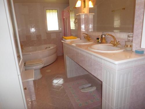 a bathroom with two sinks and a tub and a toilet at Villa Faidra in Eretria