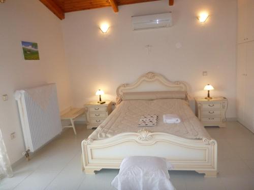 a bedroom with a large white bed with two night stands at Villa Faidra in Eretria