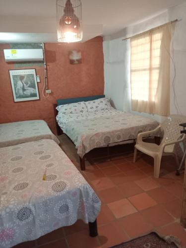 ein Zimmer mit zwei Betten und einem Tisch und einem Stuhl in der Unterkunft Hostal ROLLED in Villavieja