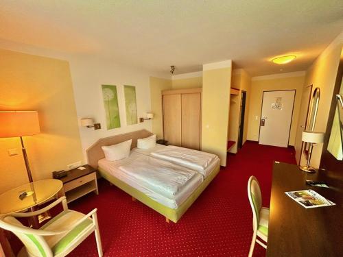 a hotel room with a bed and a table and chairs at Hotel Phönix in Bad Füssing