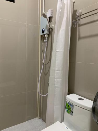 a shower with a white shower curtain in a bathroom at Home of River Kwai 2 in Kanchanaburi City