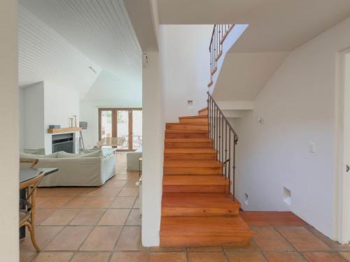 a staircase in a home with white walls and wooden floors at Casapueblo Rent Cachagua CP 29 in Cachagua